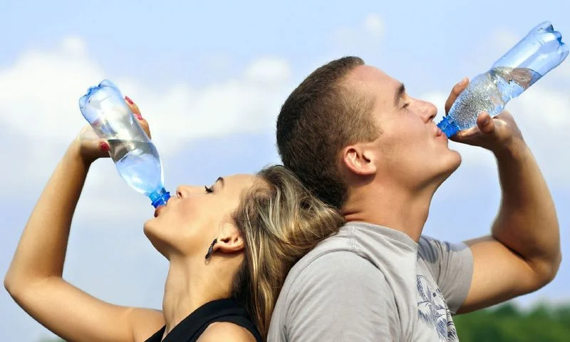 People trying to stay hydrated throughout the day by drinking water outdoors